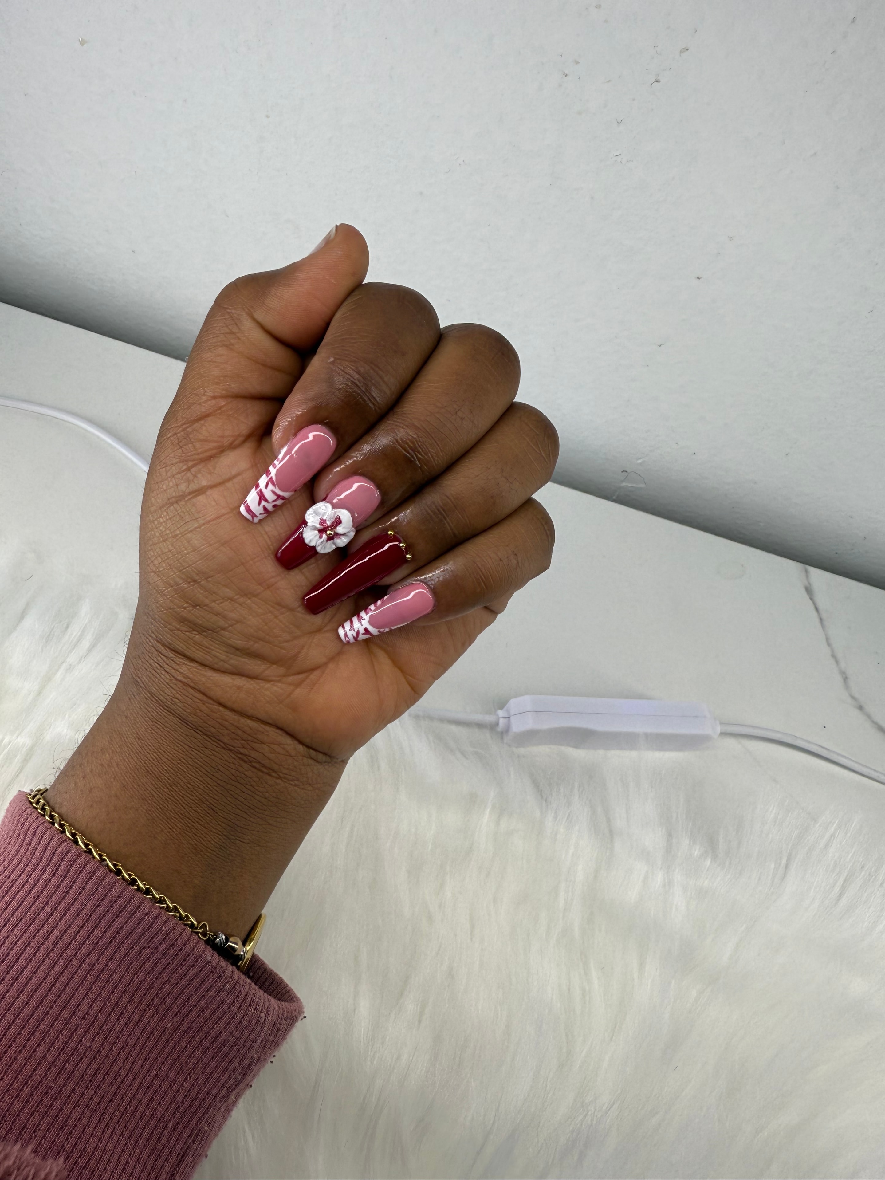Burgundy and pink nails with white floral embellishment
