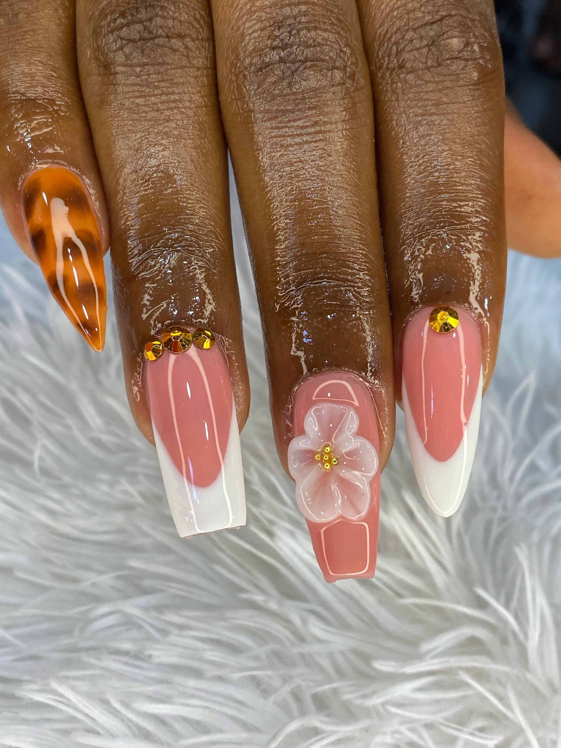 Pink ombré nails with orange accent and floral embellishment